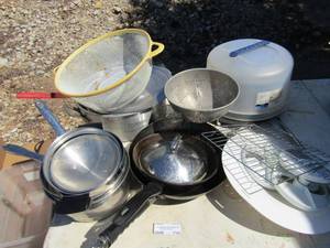 lot 238 image: Lot of plates and pans some with lids, star metal strainer, large yellow rim strainer, covered cake pan, large sauce pan with lid