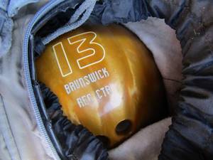lot 250 image: Black knight Columbia bowling ball, Gold Brunswick 13 bowling ball in a olive green Nike bag