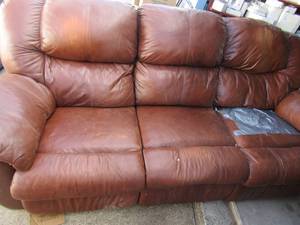 lot 30 image: brown leather couch, one end needs repair but still has lots of life, both ends recline