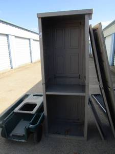 lot 90 image: Planters wagon green with fold out handle, plastic outdoor storage shelf, size 692516, doors need to be put back on, ready for install