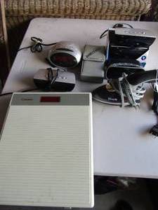 lot 115 image: Norelco bathroom scale, Dura brand alarm plus amFM radio, 2 equality alarm clocks, hand held shark steamer, plus more