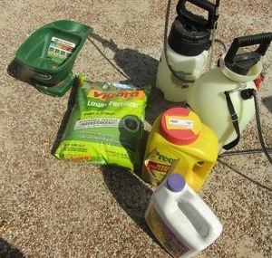 lot 187 image: used bottle of root stimulator, Scotts hand spreader, used bottle of weed preventor, new bag of lawn fertilizer, 2 hand pump round about bottles with sprayers