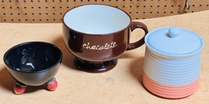 lot 401 image: Fitz and Floyd Strawberry Footed Black Bowl, Harbor East Huge Chocolate Cup, & Ribbed Pottery Container