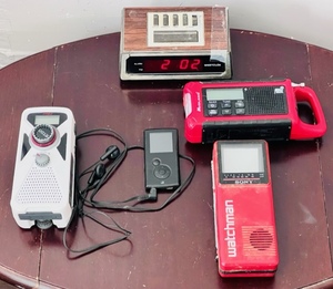 lot 120 image: Electronics Lot - Erin American Red Cross FRX2 Hand Turbine AMFMNOAA Weather RadioGPX 4GB Digital Media MP3 PlayerMidland ER210 Emergency Crank Weather RadioSony Watchman