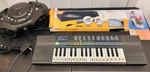 lot 160 image: Casio SA-20 Keyboard W100 Sound Tonebank  Memorex Model MP3851 BLK Portable CD Player With AMFM Stereo Radio Thunderbolt Solar 1.5 Watt Battery Charger