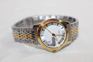 lot 60 image: Gucci Watch. Marked Gucci. Swiss Made. Two tone metal flex band. Model 15480706.