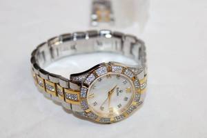 lot 80 image: Bulova watch w crystal accents. Model C9337058.Has crystal accents on two tone band as well and has extra links. Pearlized face.