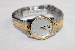 lot 82 image: Movado watch w two tone metal band. Model 07.3.20.1201. Swiss made. Damaged face