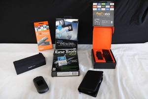 lot 214 image: Electronics FireTVstick, Samsung Flip Phone, Jambox Portable Speaker, Roxio easy VHS to DVD for Mac, Tune Tools for iPod, and Bose Earbuds with Case