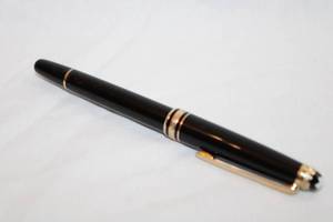 lot 32 image: MontBlanc Meisterstruck 75th Anniversary Limited Edition commemorative ball point pen. Black and gold with 75th Anniversary Of Passion script band w diamond. Diamond tested.