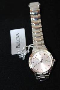 lot 35 image: Bulova diamond watch with polished silver flex band and diamond surround. Diamonds tested. 16 diamonds. Orig retail tag. Model 15986573 Rose colored face.