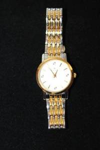 lot 36 image: Bulova diamond watch with two tone gold and silver flex band. Diamonds at the quarter hour. Model C935132 Pearlized face.