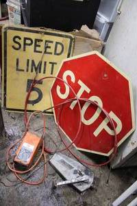 lot 145 image: Metal Stop Sign, Speed Limit 5 Sign, Black and Decker Battery Charger, Boat Trottle and Cables
