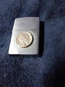 lot 184 image: Zippo Lighter Lighter has 1937 Nicole, says American Frontier and Zippo on the bottom.
