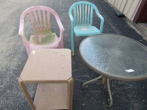 lot 45 image: Oval metal glass top table outdoor patio use 2529, 2 plastic outdoor chairs, 2 tier sqaure outdoor table needs TLC