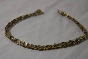 lot 48 image: Jewelry 14K yellow gold laser cut bracelet. Marked 14K 7.5L w hidden box catch and safety clasp