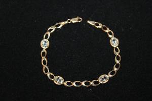 lot 321 image: 14K yellow gold oval link and gemstone station bracelet. Marked 14K. 7L
