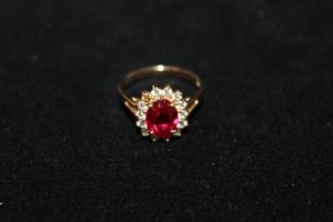 lot 345 image: 14K yellow gold Ruby and CZ halo ring. Marked 14K CZ DQ (Diamonique, Designer Quality). Size 7. Center stone tests as Ruby