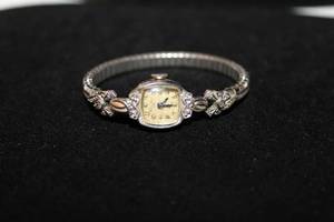 lot 353 image: Bulova 23 (L9) 10KT rolled gold and diamond watch face with diamond adorned flexible watch band. 6 diamonds total. Diamonds tested.