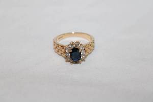 lot 372 image: 14K yellow gold Sapphire and white stone ring with basket weave shoulder design. Marked 14K. Size 7. Sapphire tested.