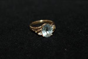 lot 387 image: 10K yellow gold Blue Topaz and white stone ring. Marked 10K. Size 6.5. Center stone tests as Blue Topaz.