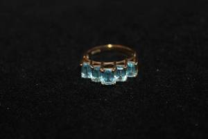 lot 385 image: 10K yellow gold Swiss Blue Topaz stepped graduated vintage ring. Marked  C.J.C. 10K. Gemstones tested. Size 7.5