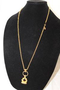 lot 404 image: Signed Joan Rivers wax seal stamp pendant on a 28L gold tone chain. Has jewelry hang tag.