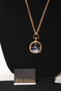 lot 402 image: Signed Joan Rivers quartz hanging watch pendant with 4 diamond markers on a 30L gold tone chain. Marked with hang tag and on watch. With booklet.