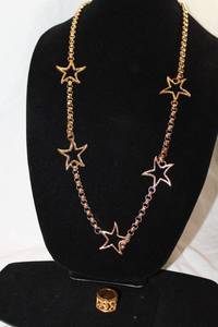 lot 415 image: Signed Givenchy large scale star station necklace w toggle clasp and coordinating moon & stars ring (size 7.5) or scarf ring. 34L. Marked Givenchy w jewelry hang tag. Givenchy also available in lot 155