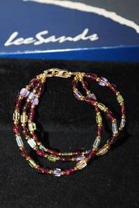 lot 439 image: Lee Sands branded multi gemstone 3-strand bracelet. Citrine, Amethyst, Peridot, Garnet and Blue Topaz. 7L. Fold over clasp. Made in Hawaii. In original box w booklet.