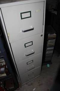 lot 62 image: Four Drawer Filing Cabinet,46 inches Tall, Filled with Knowledge. See Pictures