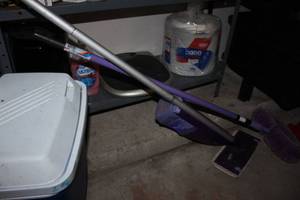 lot 109 image: Kitchen supplies, small ice chest, Swiffer, ceiling fan cleaner, dish soap, foot controlled small trash can,and large quantity of paper plates