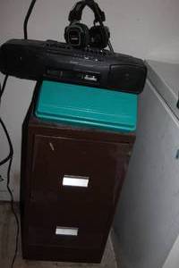 lot 175 image: Two Drawer File Cabinet with a Dual Cassette Player and two Cassette storage holders. one is full of various cassettes