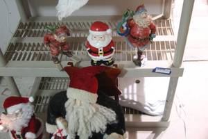 lot 229 image: Home Decor Santa Clause, Large Plush Sitting on Wooden Chair, Ceramic Santa Cookie Jar, Skiing Santa, and Santa Holding Candle