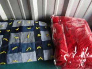 lot 154 image: Box of quilts and throws sopme hand knitted, Texas design pillow and more