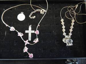 lot 67 image: Gold and pink stone necklace, glass bead with elephant drop, cross drop and catholic medal