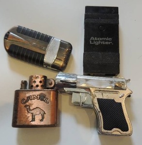 lot 78 image: 4 vintage lighters- 1 brass camel, 1 pistol, atomic lighter, and 1 vector