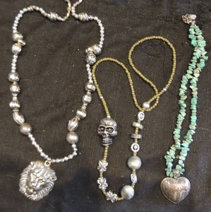 lot 62 image: Turquoise stone heart necklace, large silver tone bead necklace with lion head and sliver and glass bead with skull,