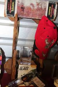 lot 60 image: Wooden Gun Rack, Gun Cleaning Kit, Red baseball cap with a Deer on it, Cigar Glass and a vintage Gun Decanter