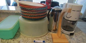 lot 220 image: green Tupperware dish with lid,  wicker plate holders, covered cake plate, Braun coffee maker and more
