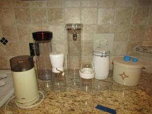 lot 266 image: milk glass sugar flour dish, pepper grinder, 2 tub like storage containers, coffee Tupperware holder