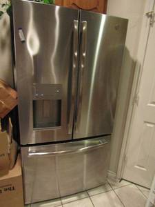 lot 38 image: GE REFRIGERATOR with bottom freezer slide out and dB top door lots of large spacious storage,  ice maker works 2 setting plus filter water 2 new filters included, model # GFE26JSMAFSS, Serial# TL305921, unknown year of make