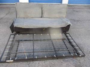 lot 62 image: Futon CouchBed With Mattress That Has A Removeable Cover And A Trundle Bed Frame On Casters. Note 2 x Money