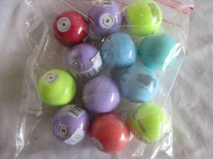 lot 105 image: 12-Italia Deluxe- Sweet Flavor Globe Lip Balm With Mineral Oil-Mixed Flavors-Loose Globes In Bag.  Note 12 x Money