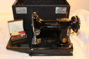 lot 77 image: Vintage Black Singer Sewing Machine and Case model AE086214 includes foot pedal, thread, bobbins, and accessories
