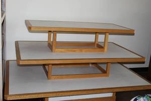 lot 9 image: 3-tiered oak and laminate retail display on wheels. Easily disassembles and assembles with no tools required. Sizes 49 x 75, 39 x 65, and 27 x 55 - Bldg. J