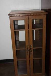 lot 20 image: Glass front oak display case with shelves on wheels - 17 x 21 x 48 - Bldg. J