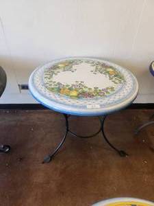 lot 55 image: Clay tabletop with lemons, oranges, and grapes on a crackled blue and white background -Table base included - 33D x 28H - Bldg. J