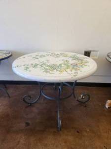 lot 145 image: Clay tabletop with a music theme - hidden amongst the flowers on a crackled white background -Table base included - 43D x 30H - Bldg. J