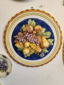 lot 110 image: Round shaped wall art of a raised depiction of fruit, set against a cobalt blue background
